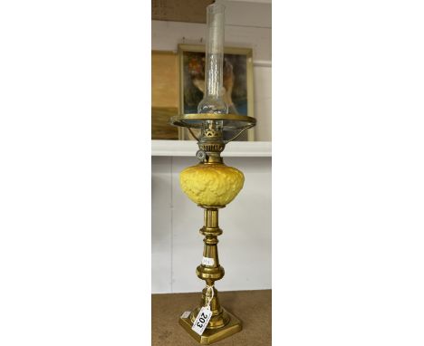 A 19th century brass drop in font candlestick oil lamp with yellow glass font and chimney.No cracks or chips. All spring clip