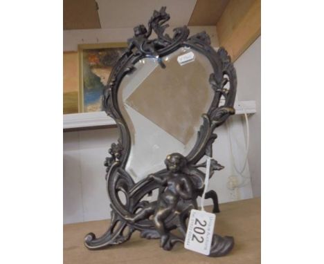 A cast metal framed mirror in the art nouveau style featuring cherubs.