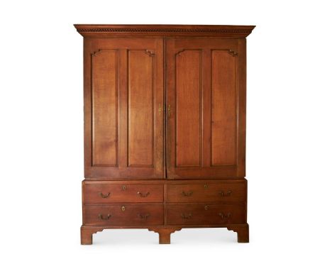 A PAIR OF GEORGE III OAK CLOTHES PRESSES  ATTRIBUTED TO ROBERT KEENE, MID 18TH CENTURY The panelled doors enclosing adjustabl