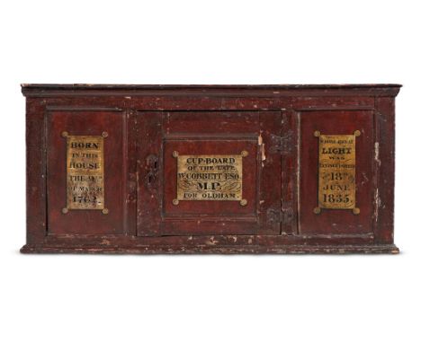 A RED PAINTED OAK JOINED WALL CUPBOARD  EARLY 18TH CENTURY AND LATER With painted inscriptions 'CUP BOARD OF THE LATE W. COBB