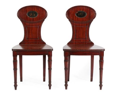 A Pair of Late George III Mahogany Hall Chairs, early 19th century, the reeded oval top rails with a recessed painted panel, 