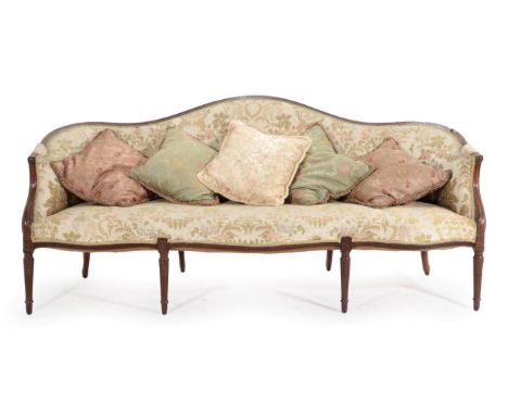 A George III Mahogany Framed Serpentine Shaped Sofa, late 18th century, recovered in green floral fabric, the fluted top rail