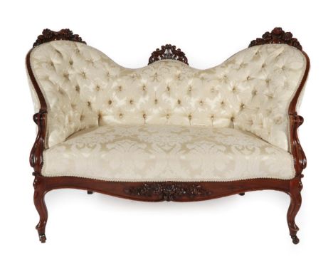 ~ A Victorian Rosewood Framed Two-Seater Sofa, 3rd quarter 19th century, recovered in floral cream fabric, the flower carved 