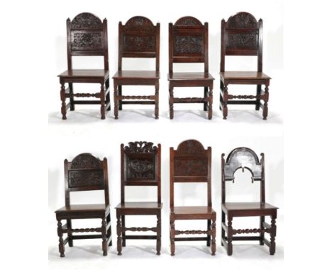 Six Lancashire Joined Oak Chairs, the domed top panel backs carved with leafy plants between plain uprights with pyramid fini