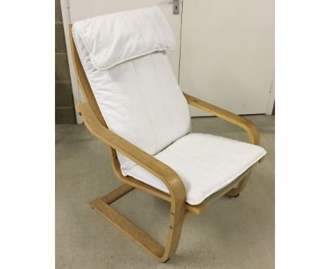 A Habitat cantilever style chair in light wood with white cushion.