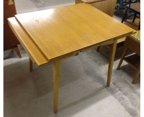 A c1970s G-plan style light wood extending kitchen/dining table.