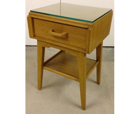 A G-plan bedside cabinet in light wood & glass topped.