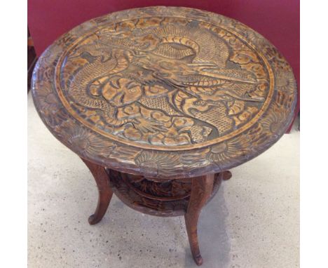 A late 19th/early 20th century carved wood table. Extensively carved with dragon to top. Edged with chrysanthemum and crane t