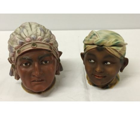 2 bisque porcelain tobacco jars in the shape of heads. One is an African child, the other is an American Indian (one repaired