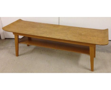 A c1970s light wood coffee table with ends curving upwards.