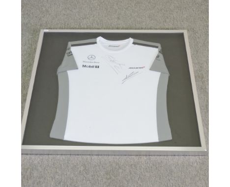 A McLaren Formula 1 racing t shirt, signed by Jenson Button in black pen, framed, 82 x 81cm