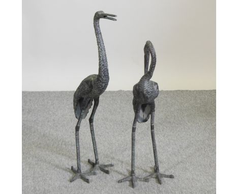 A metal garden model of a crane, 82cm high, together with another