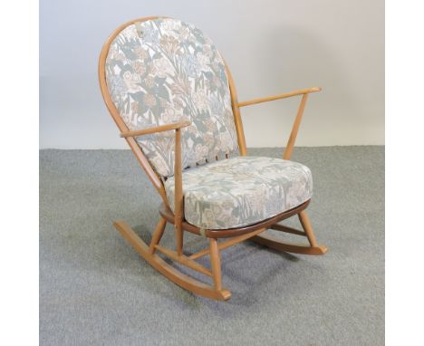 An Ercol light elm rocking chair, with cushions