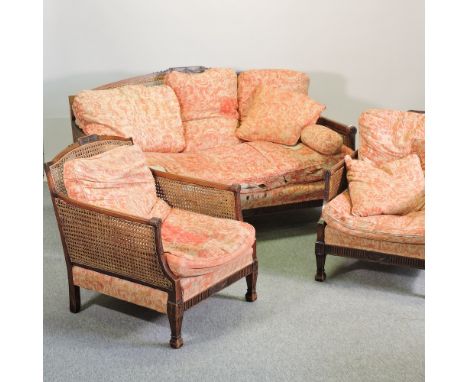 A 1920's double cane bergere suite, comprising a sofa, 156cm and a pair of armchairs