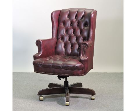 A red upholstered button back swivel desk chair