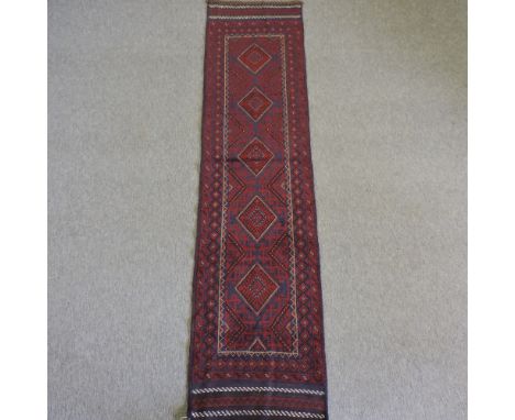 A Persian woollen runner, with geometric design on a red ground, 242 x 58cm