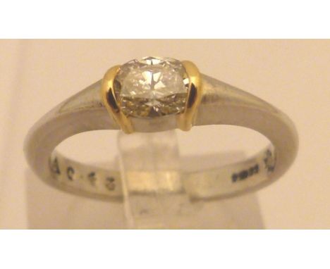 PLATINUM DIAMOND RING. Platinum diamond ring oval brilliant cut stone 0,43 ct set sideways across finger in yellow gold bands