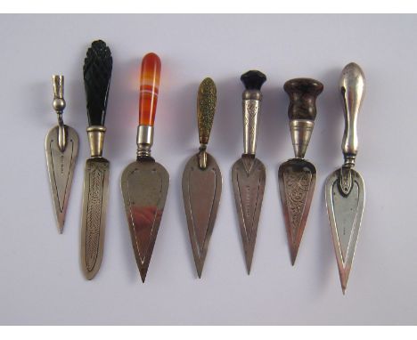 A group of seven silver and white metal trowel page markers with various mainly hardstone handles, one handle missing. 