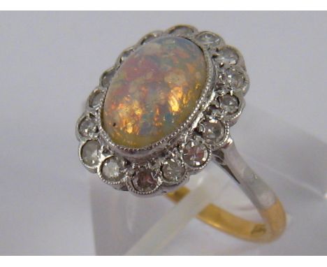 A yellow metal (tests 18 carat gold) opal and diamond ring, opal approx 10 x 7mm, estimated total diamond content approx 0.35