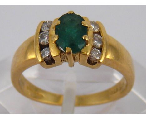 An 18 carat gold emerald and diamond ring, emerald approx 6 x 4mm, ring size K, 3.4 gms