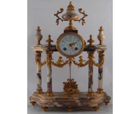 A French 8 day gilt mounted marble mantel clock striking on a bell, having four columns rising from a shaped base to a confor