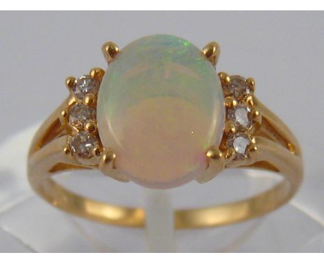 A yellow metal (tests 14 carat gold) opal and diamond ring, opal approx 9 x 7mm, ring size K, 2.1 gms.
