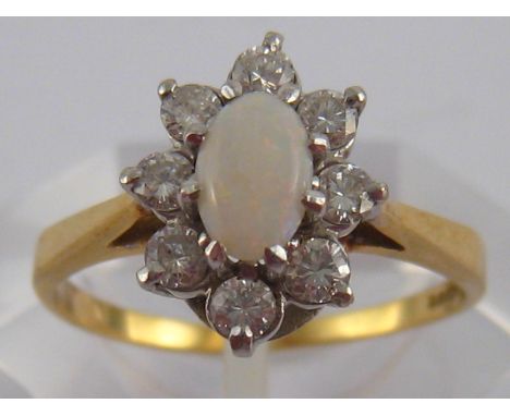 An 18 carat gold opal and diamond ring, opal approx 6 x 4mm, estimated diamond content approx 0.30 carat, ring size K, 2.4 gm