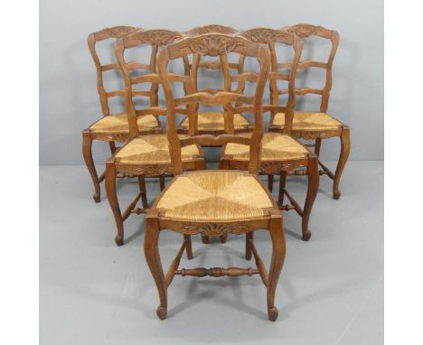 A set of six French oak rush-seated ladder-back dining chairs. 