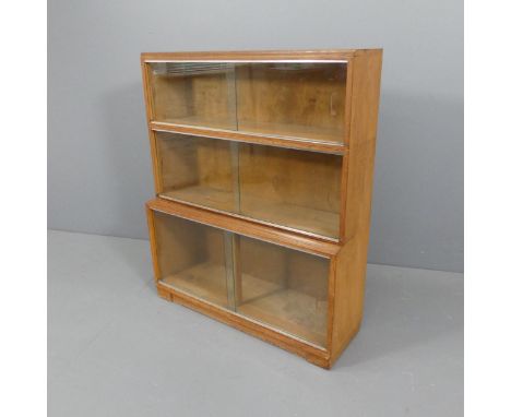 MINTY - A mid-century oak three shelf sectional stacking bookcase with sliding glazed doors and maker's label. 89x108x30cm. 
