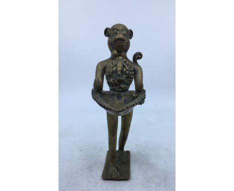 A 20th century Indian brass lamp,&nbsp;fashioned as a monkey holding leaf form lamp with Ganesha, height 21cm.