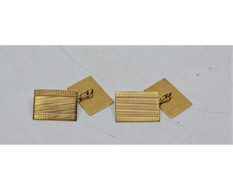 A pair of 9ct. gold engine turned rectangular cuff links, chain fitting. (7.4g)
