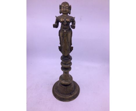 A 19th century Indian brass figural lamp, fashioned in two parts, the top with figure (lacking lamp to hands), the base with 