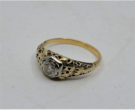 A precious yellow metal and diamond ring, set single round cut diamond to raised hexagonal centre, with pierced gallery/shoul