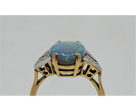 An 18ct. gold, synthetic opal and diamond ring, the centre set oval synthetic opal with three round cut diamonds to each shou