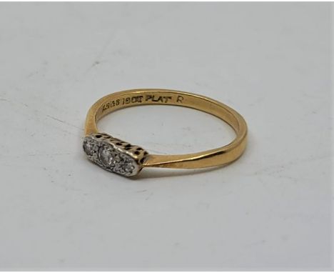 An 18ct. gold and platinum three stone diamond ring, set three graduated round cut diamonds.(gross weight 1.9g). Size UK O.