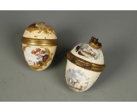 AN ENAMEL BONBONNIERE in the shape of an egg, with gilt metal mounts, four cartouches painted with sheep and goats, on a yell