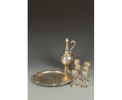 A VIETNAMESE WHITE METAL LIQUER SET comprising decanter, six small goblets and tray, decorated in relief with boating scenes 