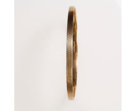 A 9CT YELLOW GOLD SLAVE BANGLE, with engine turned decoration, hallmarked c.14.7g