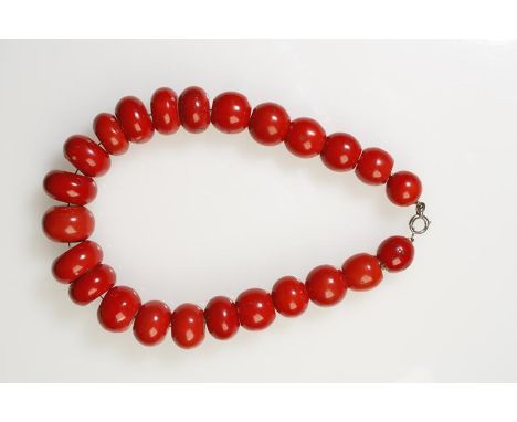 A GRADUATED CORAL BOULDER BEAD NECKLACE, the largest red coral bead c.28mm wide, the smallest c.20mm wide, united by a white 