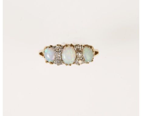 AN OPAL AND DIAMOND RING, rub-over claw set with three graduated oval opal cabochons, flanked by two rows of three graduated 