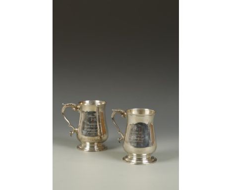 A PAIR OF GEORGE III STYLE PRESENTATION MUGS of baluster form, the scrolling handles with cast leaf decoration, engraved with