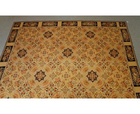AN ENGLISH NEEDLEWORK CARPET of Victorian design, the pale beige ground worked with numerous pastel shaded multi-coloured flo