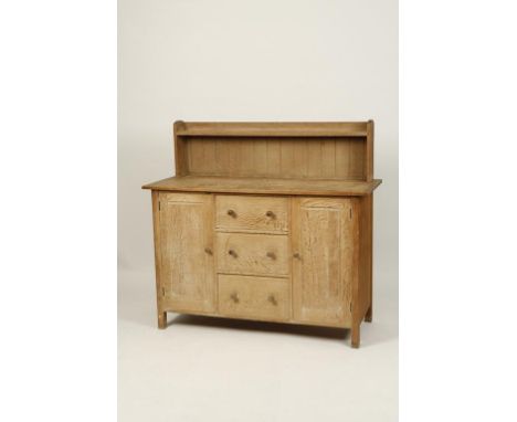 HEAL & SONS OF TOTTENHAM COURT ROAD: A LIMED OAK DRESSER, the low back with a single shelf above a rectangular top above thre