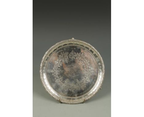 A VICTORIAN SALVER of circular form with a raised leaf and berry border, the centre engraved with a presentation inscription,