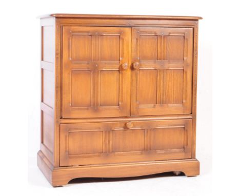 Ercol - A mid 20th century Ercol golden dawn elm TV / drinks cabinet. The cabinet featuring twin doors to front over drop doo