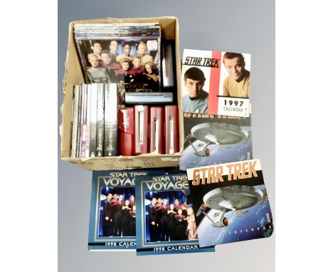 A box containing Star Wars collectibles including vintage rolled poster, calendars, books, DVD box sets, a model of the USS E