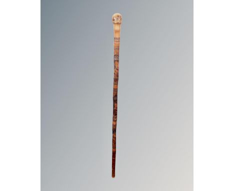 A vintage Oriental carved bamboo walking stick depicting geishas.