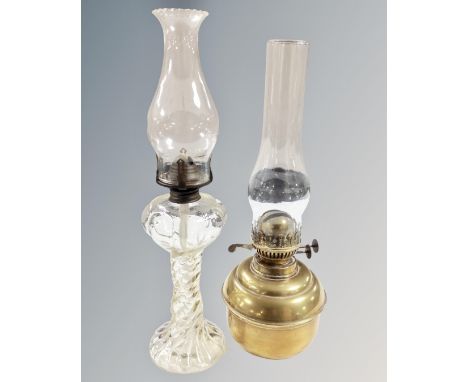 A duplex brass oil lamp with chimney together with a further clear glass oil lamp with chimney.