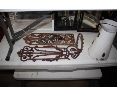 A enamel jug and two metal racks 