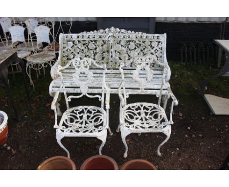 A white painted ornate wood and metal garden bench together with two white painted ornate chairs